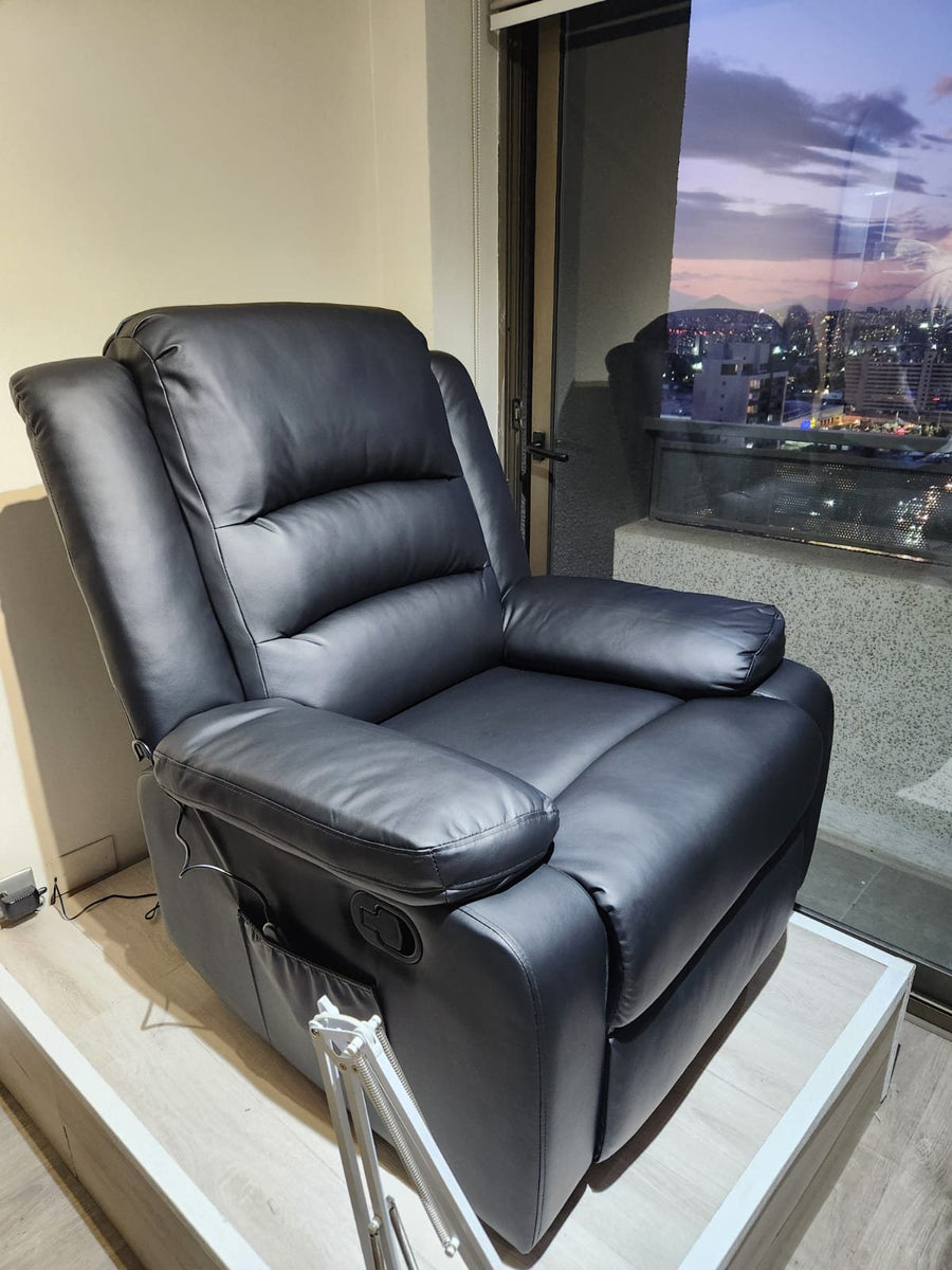 Sillón reclinable negro de un cliente, junto a una ventana con vista a la ciudad