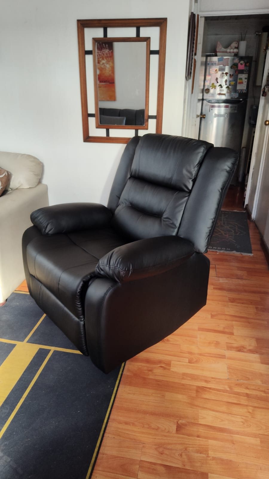 Sillón reclinable negro en el living de un cliente